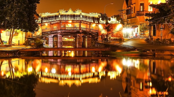 japanese-covered-bridge-at-night-with-lantern-lights-reflected-on-the-water
